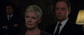 Movie still from “The World Is Not Enough” (1999), directed by Michael Apted – An older woman and a younger man standing next to each other; Close Up shot, Low angle