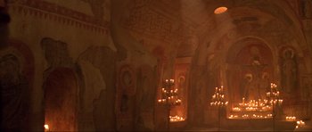 Movie still from “The World Is Not Enough” (1999), directed by Michael Apted – A room with candles and a painting on the wall; Extreme Wide shot, High angle