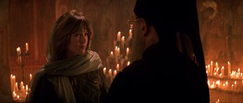 Movie still from “The World Is Not Enough” (1999), directed by Michael Apted – A man and a woman standing in front of candles; Medium shot, Over the shoulder angle