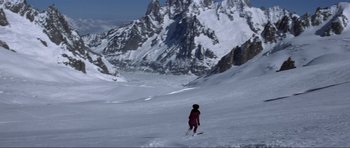 Movie still from “The World Is Not Enough” (1999), directed by Michael Apted – A person is standing in the middle of a snow covered slope; Extreme Wide shot, High angle