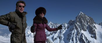 Movie still from “The World Is Not Enough” (1999), directed by Michael Apted – A woman standing on top of a snow covered slope; Wide shot, Low angle