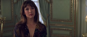 Movie still from “The World Is Not Enough” (1999), directed by Michael Apted – A woman in a floral shirt standing next to a window; Close Up shot, Over the shoulder angle
