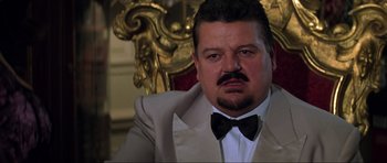 Movie still from “The World Is Not Enough” (1999), directed by Michael Apted – A person wearing a suit and bow tie; Close Up shot, Low angle