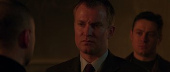 Movie still from “The World Is Not Enough” (1999), directed by Michael Apted – A person wearing a suit and tie; Close Up shot, Low angle