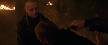 Movie still from “The World Is Not Enough” (1999), directed by Michael Apted – A man is getting his hair brushed by another man; Close Up shot, Over the shoulder angle