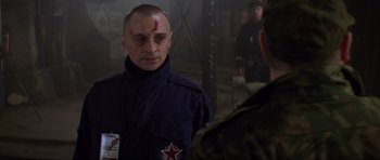 Movie still from “The World Is Not Enough” (1999), directed by Michael Apted – A man with a bandage on his head and forehead is looking at another man; Close Up shot, Over the shoulder angle