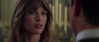 Movie still from “The World Is Not Enough” (1999), directed by Michael Apted – A woman's face in front of candles; Close Up shot, Over the shoulder angle