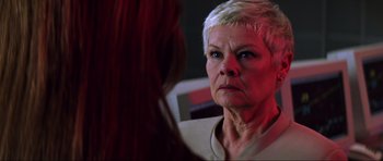 Movie still from “The World Is Not Enough” (1999), directed by Michael Apted – An older woman looking into a mirror with red light behind her; Close Up shot, Over the shoulder angle