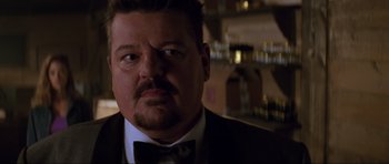 Movie still from “The World Is Not Enough” (1999), directed by Michael Apted – A person wearing a suit and a bow tie; Close Up shot, Over the shoulder angle