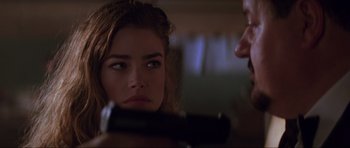 Movie still from “The World Is Not Enough” (1999), directed by Michael Apted – A woman looking into a mirror while holding a gun; Close Up shot, Over the shoulder angle