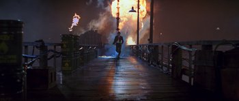 Movie still from “The World Is Not Enough” (1999), directed by Michael Apted – A man is running on a bridge at night; Extreme Wide shot, High angle