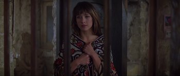 Movie still from “The World Is Not Enough” (1999), directed by Michael Apted – A woman standing behind bars with her hands on her chest; Close Up shot, Low angle