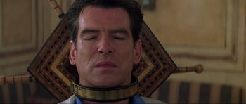 Movie still from “The World Is Not Enough” (1999), directed by Michael Apted – A man wearing a neck brace; Close Up shot, High angle