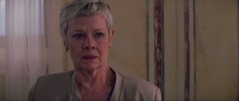 Movie still from “The World Is Not Enough” (1999), directed by Michael Apted – An older woman with short grey hair looking at the camera; Close Up shot, Low angle