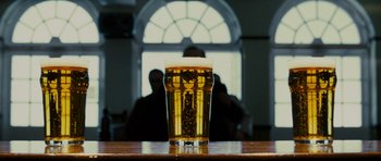 Movie still from “The World's End” (2013), directed by Edgar Wright – A glass of beer on a wooden table in front of a window; Extreme Close Up shot, Low angle