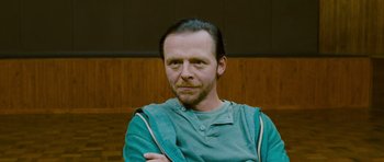 Movie still from “The World's End” (2013), directed by Edgar Wright – A man in a green shirt with his arms crossed; Close Up shot, Over the shoulder angle