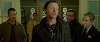 Movie still from “The World's End” (2013), directed by Edgar Wright – A group of men standing next to each other in a room; Close Up shot, Over the shoulder angle