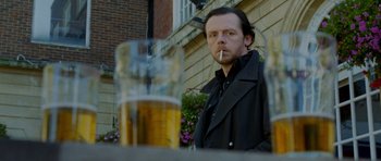 Movie still from “The World's End” (2013), directed by Edgar Wright – A man standing next to a glass of beer; Close Up shot, Low angle