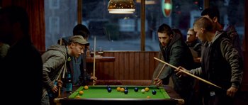 Movie still from “The World's End” (2013), directed by Edgar Wright – A group of men playing a game of billiards; Medium shot, Over the shoulder angle