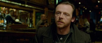 Movie still from “The World's End” (2013), directed by Edgar Wright – A person sitting in front of a bar; Close Up shot, Over the shoulder angle