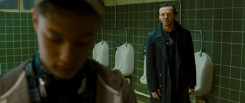 Movie still from “The World's End” (2013), directed by Edgar Wright – A man standing in front of urinals in a bathroom; Medium shot, Over the shoulder angle