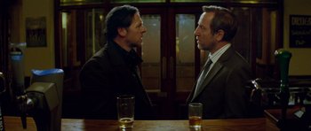 Movie still from “The World's End” (2013), directed by Edgar Wright – Two men in business suits talking at a bar; Medium shot, Over the shoulder angle