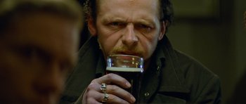 Movie still from “The World's End” (2013), directed by Edgar Wright – A person holding a glass of beer; Close Up shot, Low angle
