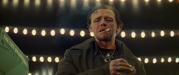 Movie still from “The World's End” (2013), directed by Edgar Wright – A man smoking a cigarette in front of lights; Close Up shot, Low angle