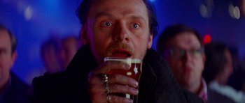Movie still from “The World's End” (2013), directed by Edgar Wright – A person holding a cup of beer; Close Up shot, Low angle