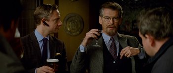 Movie still from “The World's End” (2013), directed by Edgar Wright – A man in a suit holding a wine glass; Medium shot, Over the shoulder angle