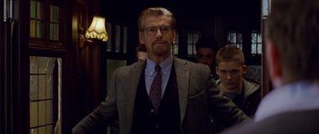 Movie still from “The World's End” (2013), directed by Edgar Wright – A man in a suit and tie standing in front of other men; Medium shot, Over the shoulder angle