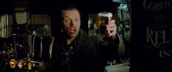 Movie still from “The World's End” (2013), directed by Edgar Wright – A man holding up a glass of beer in his hand; Close Up shot, Low angle
