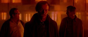 Movie still from “The World's End” (2013), directed by Edgar Wright – A man with a cross on his chest is standing in the dark; Close Up shot, Low angle