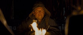 Movie still from “The World's End” (2013), directed by Edgar Wright – A man in a hooded jacket is sitting in front of a fire; Close Up shot, Low angle