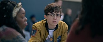 Movie still from “There's Someone Inside Your House” (2021), directed by Patrick Brice – A young man wearing glasses and a yellow jacket; Close Up shot, Over the shoulder angle