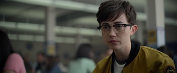 Movie still from “There's Someone Inside Your House” (2021), directed by Patrick Brice – A person with glasses is looking at the camera; Close Up shot, Over the shoulder angle