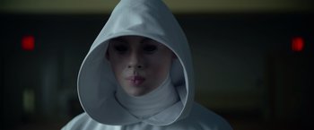 Movie still from “There's Someone Inside Your House” (2021), directed by Patrick Brice – A woman wearing a white hood and a white robe; Close Up shot, Over the shoulder angle