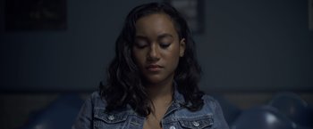 Movie still from “There's Someone Inside Your House” (2021), directed by Patrick Brice – A young woman with her eyes closed; Close Up shot, Low angle