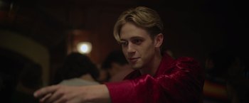 Movie still from “There's Someone Inside Your House” (2021), directed by Patrick Brice – A young man in a red shirt is looking at the camera; Close Up shot, Over the shoulder angle