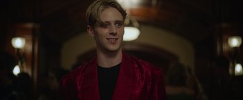 Movie still from “There's Someone Inside Your House” (2021), directed by Patrick Brice – A young man in a red jacket smiling for the camera; Close Up shot, Low angle
