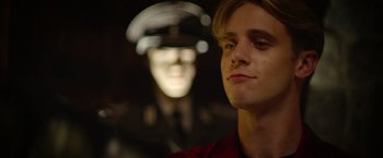 Movie still from “There's Someone Inside Your House” (2021), directed by Patrick Brice – A man in a red shirt and a man in a black hat; Close Up shot, Over the shoulder angle