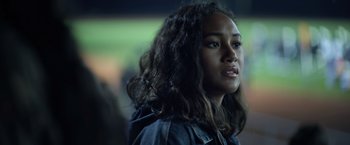 Movie still from “There's Someone Inside Your House” (2021), directed by Patrick Brice – A woman with long hair is looking at the camera; Close Up shot, Over the shoulder angle