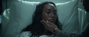 Movie still from “There's Someone Inside Your House” (2021), directed by Patrick Brice – A woman laying in a hospital bed with her eyes closed; Close Up shot, High angle