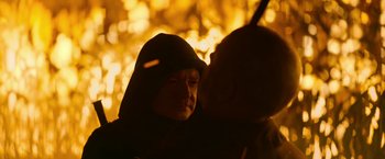 Movie still from “There's Someone Inside Your House” (2021), directed by Patrick Brice – Two people in hooded jackets are standing in front of a tree; Close Up shot, Over the shoulder angle