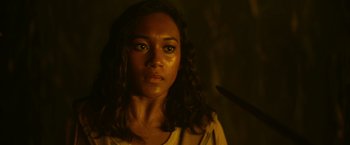 Movie still from “There's Someone Inside Your House” (2021), directed by Patrick Brice – A woman with long dark hair and green eyes stares into the camera; Close Up shot, Over the shoulder angle