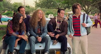 Movie still from “There's Something About Mary” (1998), directed by Bobby Farrelly – A group of people sitting on top of a car; Medium shot, Low angle