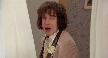 Movie still from “There's Something About Mary” (1998), directed by Bobby Farrelly – A man in a brown suit with a flower in his hair; Close Up shot, Low angle