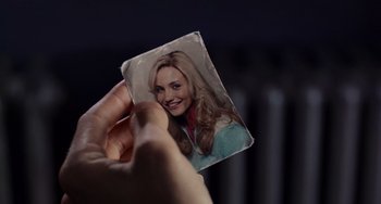 Movie still from “There's Something About Mary” (1998), directed by Bobby Farrelly – A person holding up a picture of a woman; Extreme Close Up shot, High angle