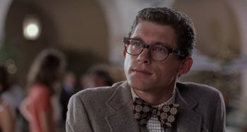 Movie still from “There's Something About Mary” (1998), directed by Bobby Farrelly – A person wearing glasses and a bow tie; Close Up shot, Low angle