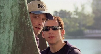 Movie still from “There's Something About Mary” (1998), directed by Bobby Farrelly – Two men standing next to each other next to a tree; Close Up shot, Low angle